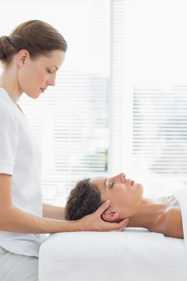 Relaxed woman receiving massage from physical therapist